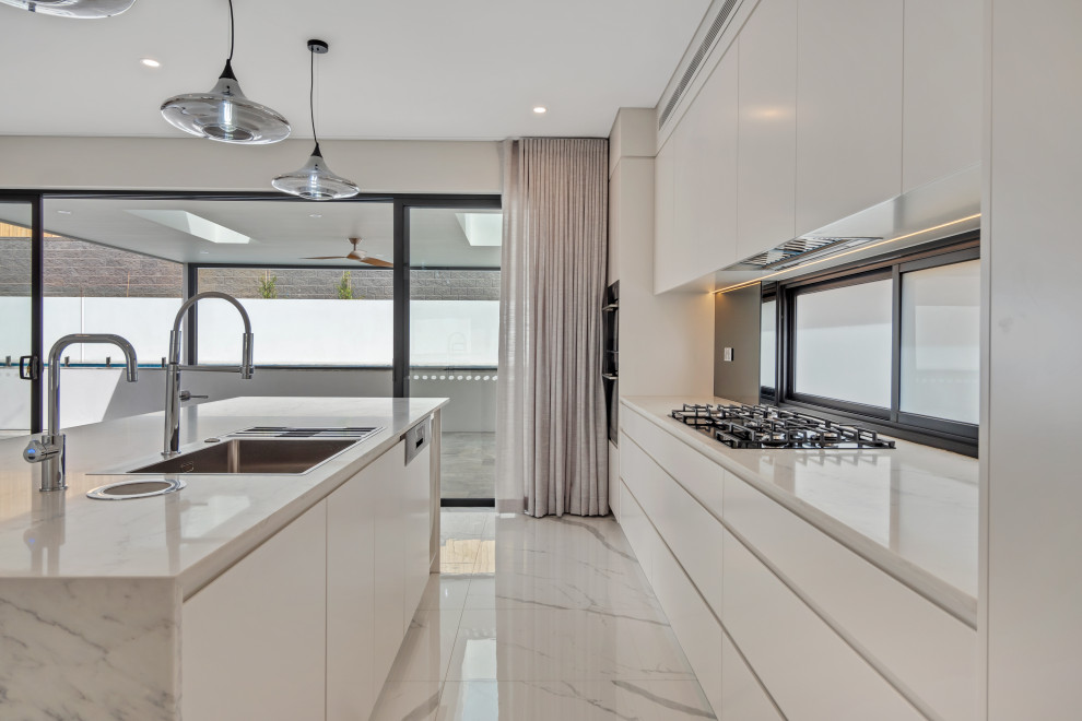 Inspiration for a mid-sized modern galley eat-in kitchen in Sydney with a drop-in sink, flat-panel cabinets, white cabinets, quartz benchtops, white splashback, with island and white benchtop.