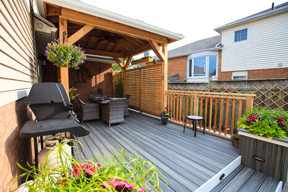 This is an example of a small beach style side yard deck in Toronto with a roof extension.