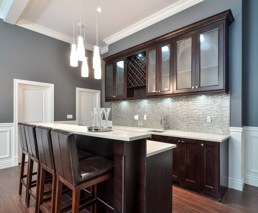 Mid-sized contemporary galley seated home bar in Vancouver with shaker cabinets, dark wood cabinets, grey splashback, an undermount sink, quartzite benchtops, glass tile splashback and medium hardwood floors.