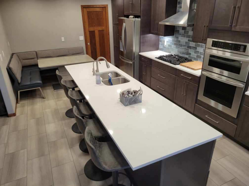 Inspiration for a large contemporary single-wall eat-in kitchen in Nashville with an undermount sink, flat-panel cabinets, quartz benchtops, subway tile splashback, stainless steel appliances, with island, beige benchtop and recessed.