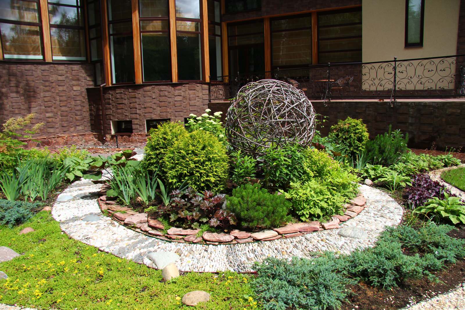 Modern house with a big flowerbad with a sphere