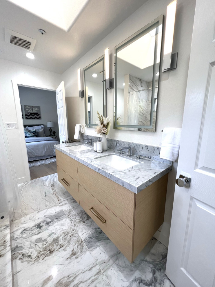 Small contemporary 3/4 bathroom in San Francisco with flat-panel cabinets, light wood cabinets, an undermount tub, an alcove shower, a one-piece toilet, gray tile, marble, white walls, marble floors, an undermount sink, marble benchtops, grey floor, a shower curtain, white benchtops, a double vanity and a floating vanity.