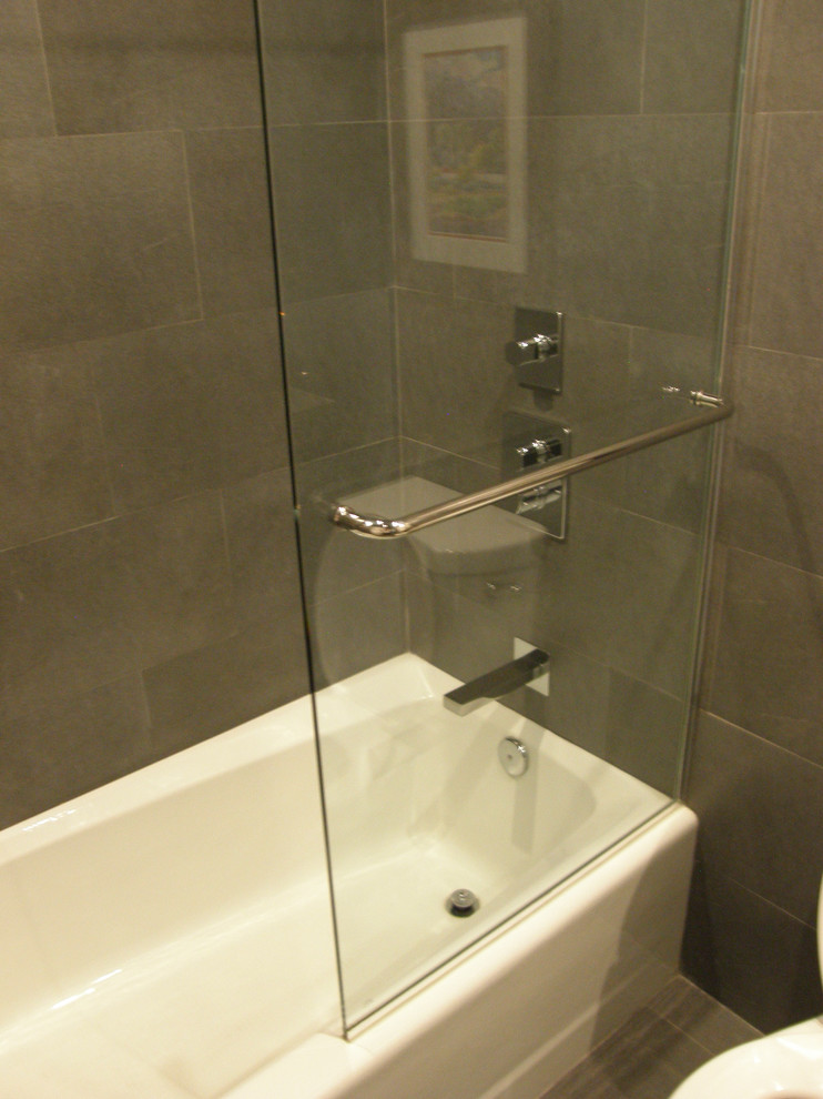 Ejemplo de cuarto de baño minimalista con armarios con paneles lisos, puertas de armario negras, baldosas y/o azulejos grises, baldosas y/o azulejos de porcelana, paredes grises y suelo de baldosas de porcelana
