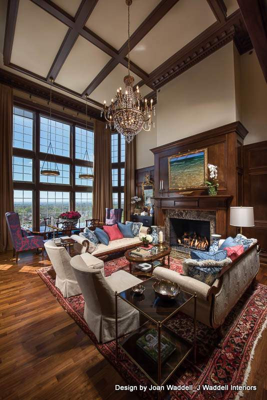 Exemple d'un grand salon chic ouvert avec une salle de réception, un sol en bois brun, une cheminée standard, un manteau de cheminée en pierre, poutres apparentes et du lambris.