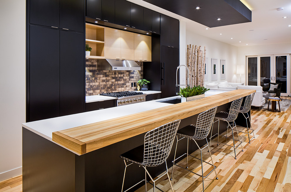Photo of a contemporary open plan kitchen in Calgary with flat-panel cabinets and black cabinets.