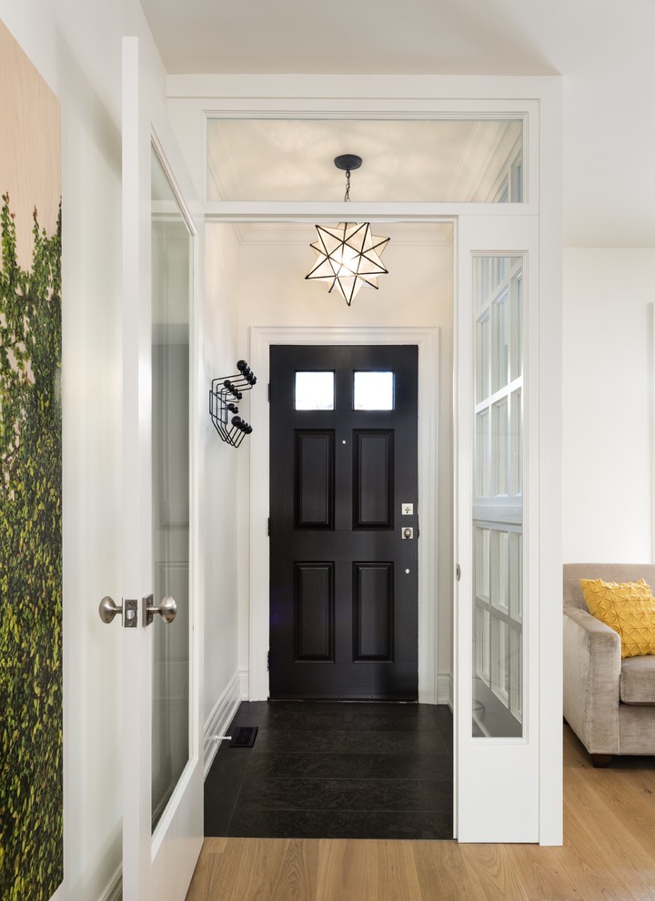 Photo of a small transitional vestibule in Toronto with white walls, granite floors, a single front door and a dark wood front door.