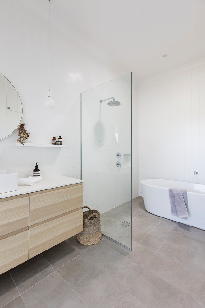 Inspiration for a large country master bathroom in Wollongong with a freestanding tub, an open shower, white tile, ceramic tile, white walls, engineered quartz benchtops, grey floor, white benchtops, flat-panel cabinets, light wood cabinets, a vessel sink and an open shower.