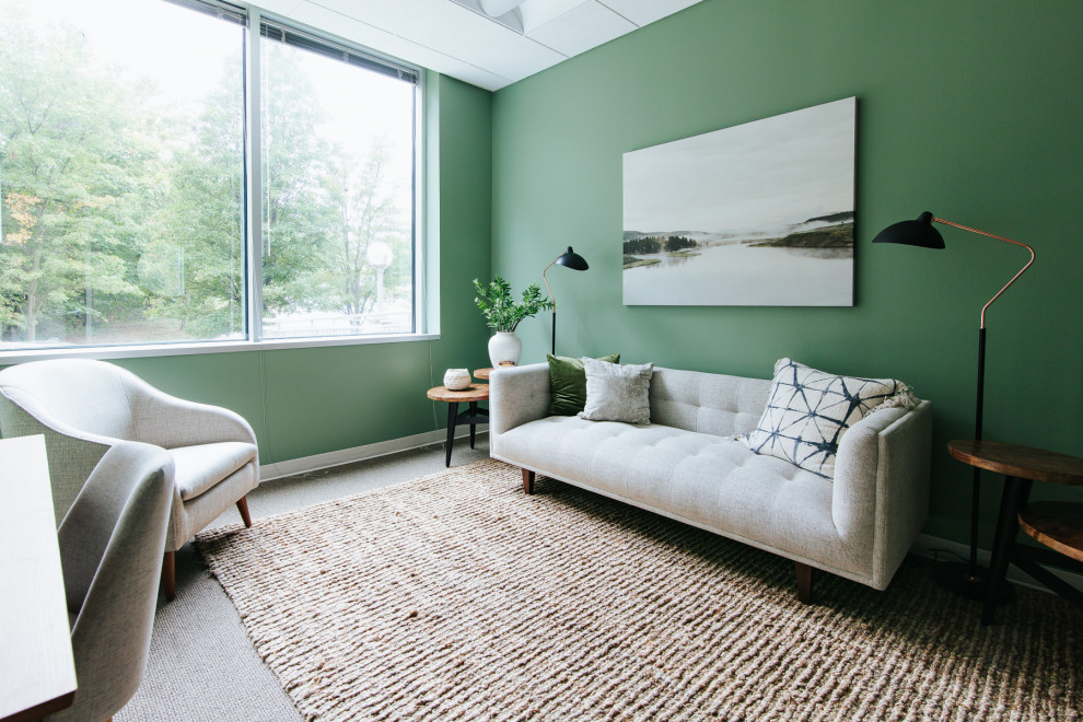 Foto di un ampio studio minimalista con pareti verdi e pavimento marrone