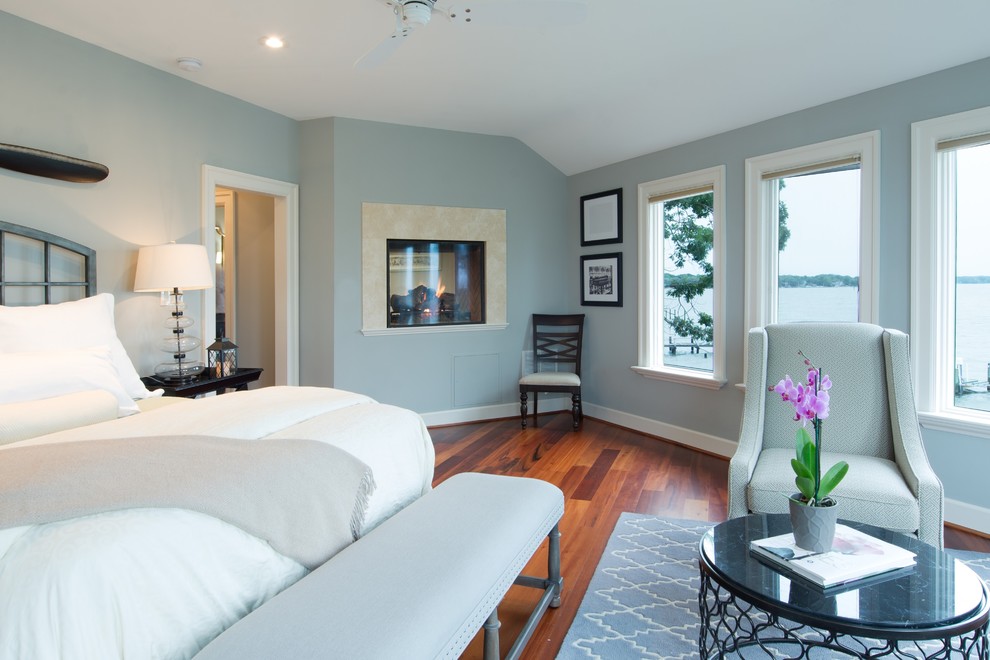 This is an example of a mid-sized contemporary master bedroom in DC Metro with blue walls, medium hardwood floors, a two-sided fireplace and a stone fireplace surround.