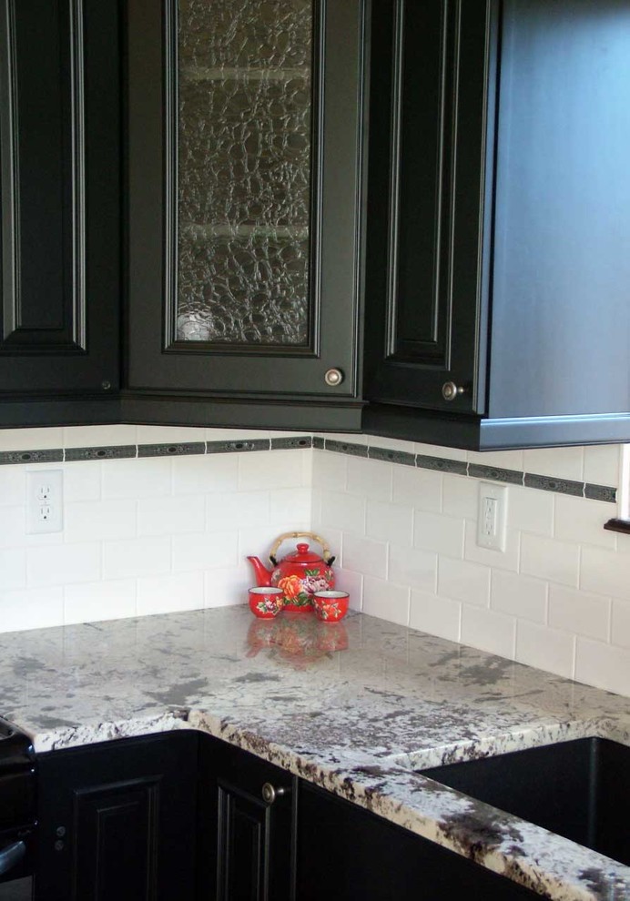 Mid-sized transitional u-shaped light wood floor open concept kitchen photo in Denver with an undermount sink, beaded inset cabinets, black cabinets, marble countertops, white backsplash, subway tile backsplash, stainless steel appliances and a peninsula