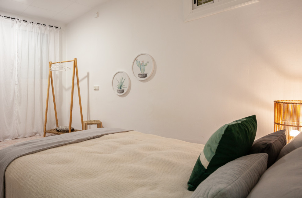 Diseño de dormitorio principal y beige y rosa mediterráneo de tamaño medio con paredes blancas y suelo rosa