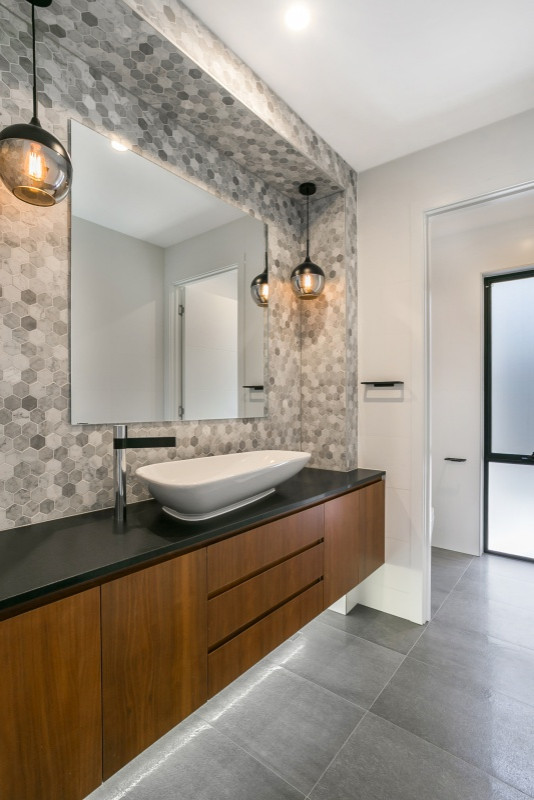 Photo of a mid-sized contemporary bathroom in Brisbane with medium wood cabinets, gray tile, ceramic tile, ceramic floors, engineered quartz benchtops, grey floor and black benchtops.
