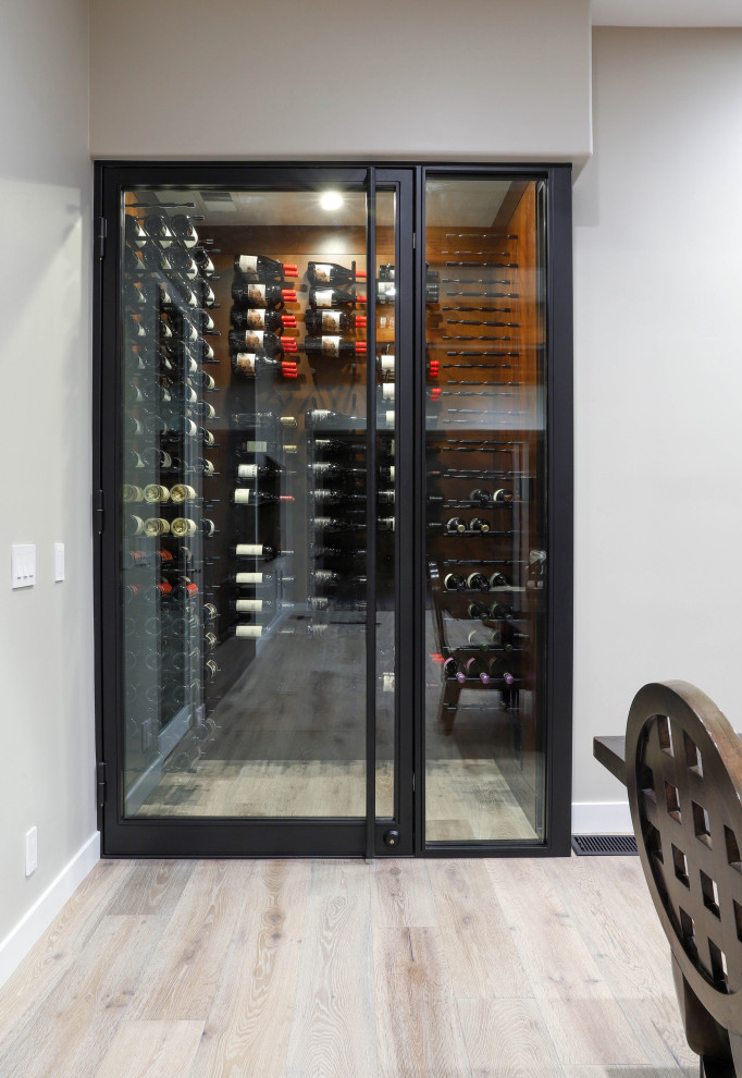 Small traditional wine cellar in San Diego with light hardwood floors, display racks and beige floor.