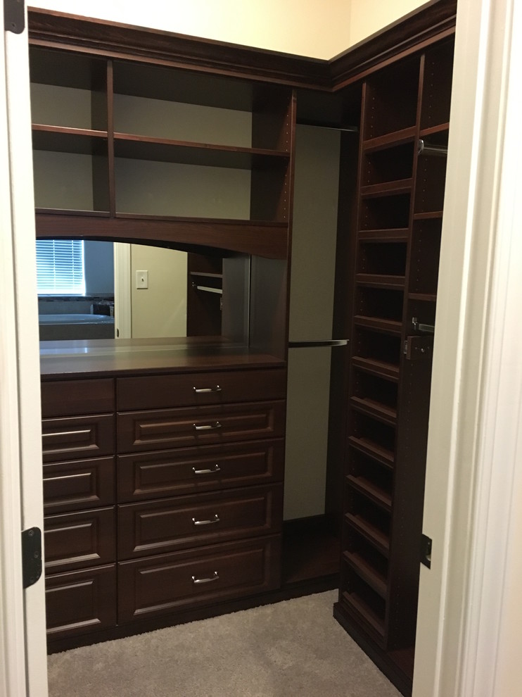 Inspiration for a mid-sized traditional men's walk-in wardrobe in Richmond with raised-panel cabinets, dark wood cabinets and carpet.