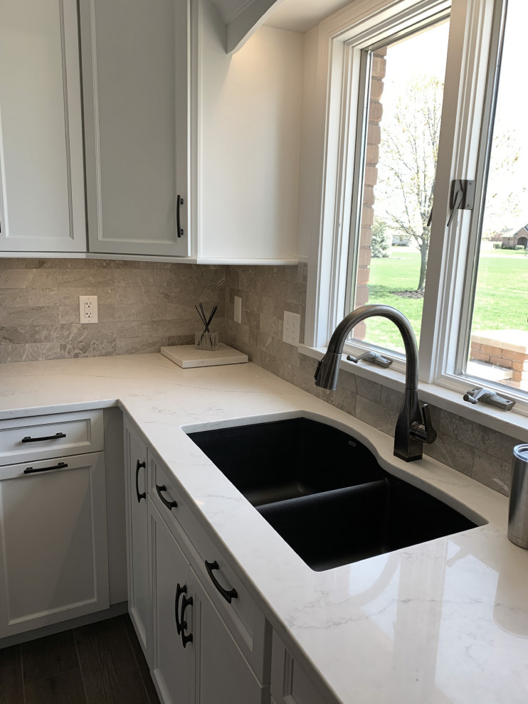 Eat-in kitchen - large transitional l-shaped vinyl floor and gray floor eat-in kitchen idea with an undermount sink, recessed-panel cabinets, white cabinets, quartz countertops, gray backsplash, ceramic backsplash, stainless steel appliances, an island and white countertops