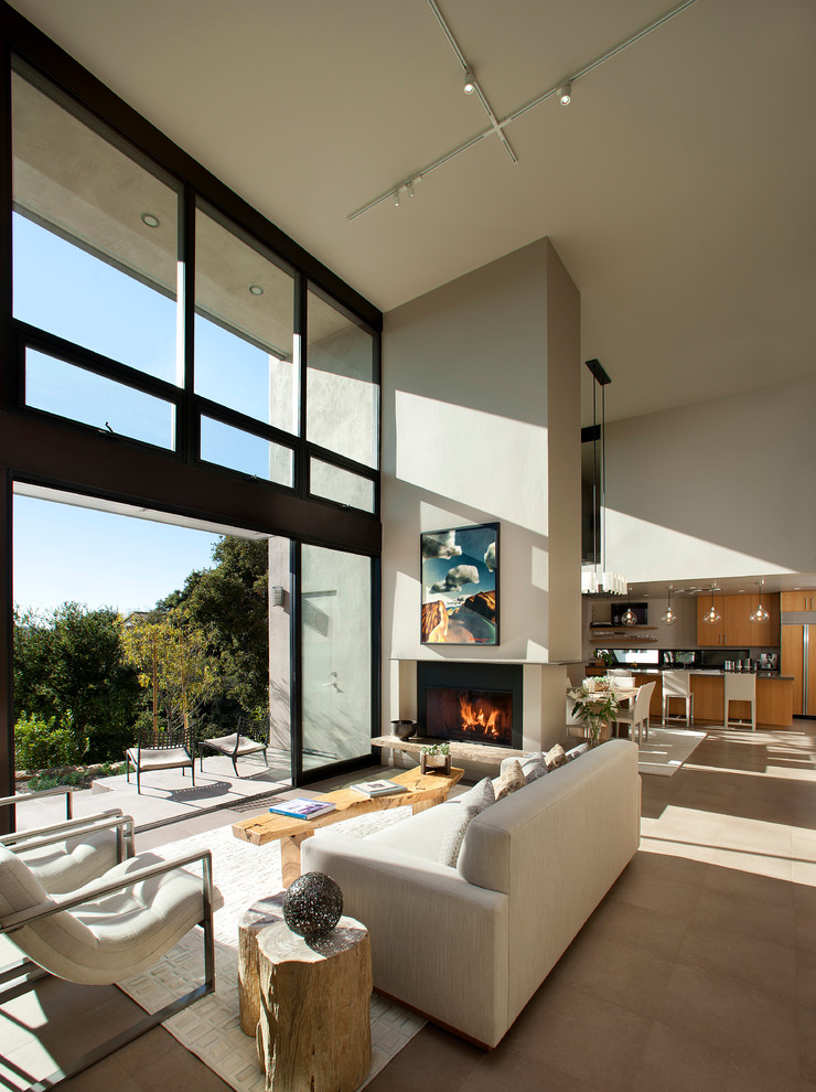 Large contemporary open concept living room in Santa Barbara with beige walls, a standard fireplace, no tv and beige floor.
