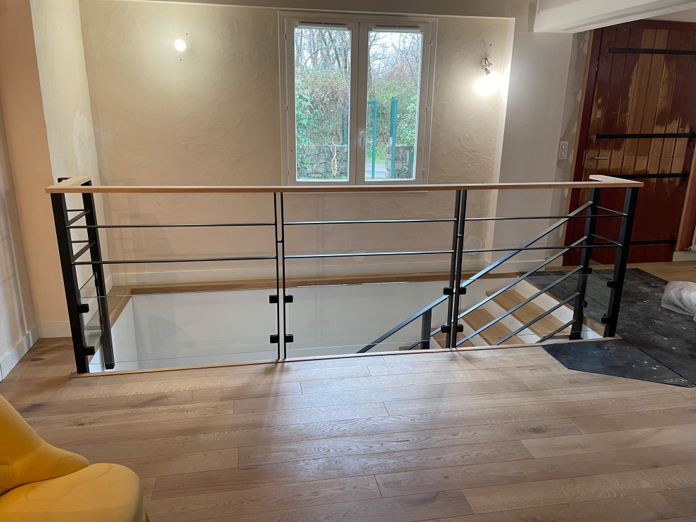 Example of a mid-sized trendy wooden l-shaped metal railing and wallpaper staircase design in Bordeaux with concrete risers