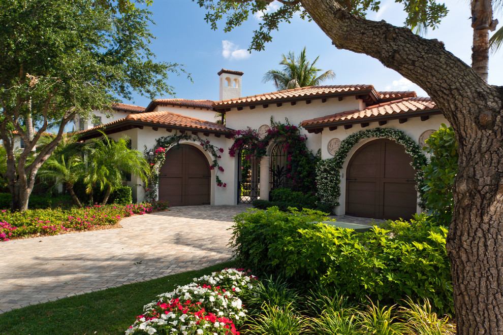 Photo of a mediterranean one-storey white exterior in Miami with a hip roof.