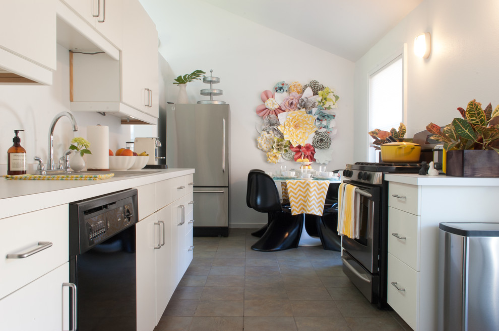 Photo of an eclectic galley eat-in kitchen in Dallas with flat-panel cabinets, white cabinets and stainless steel appliances.