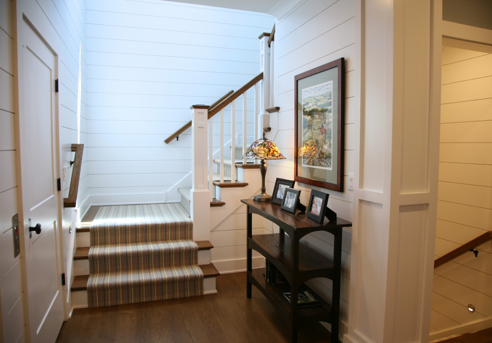 This is an example of a mid-sized beach style wood u-shaped staircase in Milwaukee with painted wood risers, mixed railing and planked wall panelling.