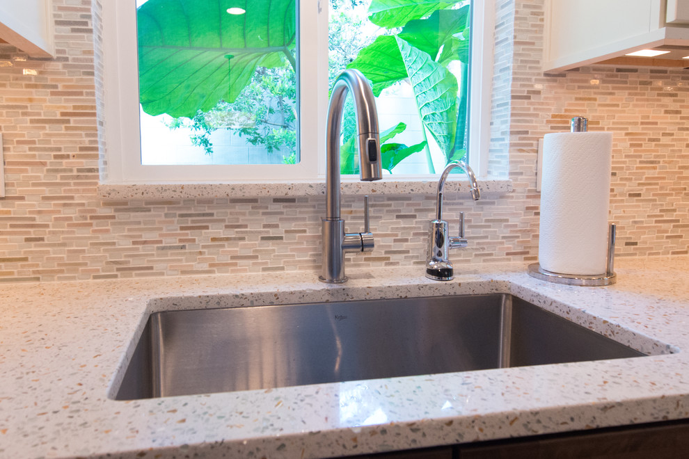 Photo of a modern u-shaped open plan kitchen in Portland with an undermount sink, recycled glass benchtops, glass tile splashback, stainless steel appliances and a peninsula.