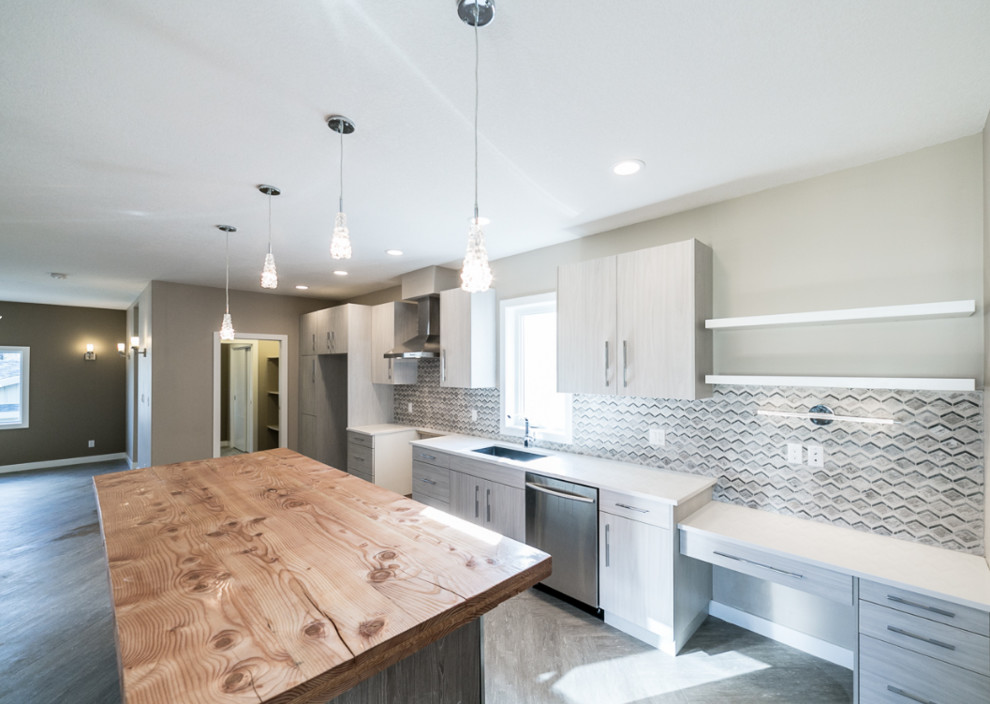 Inspiration for a large transitional galley vinyl floor open concept kitchen remodel in Edmonton with an undermount sink, flat-panel cabinets, distressed cabinets, wood countertops, multicolored backsplash, porcelain backsplash, stainless steel appliances and an island