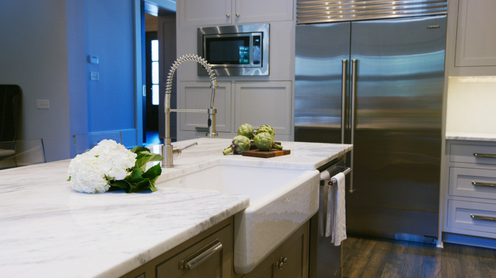 Inspiration for a large transitional u-shaped dark wood floor, gray floor and exposed beam eat-in kitchen remodel with a farmhouse sink, flat-panel cabinets, gray cabinets, quartzite countertops, gray backsplash, subway tile backsplash, stainless steel appliances, an island and white countertops