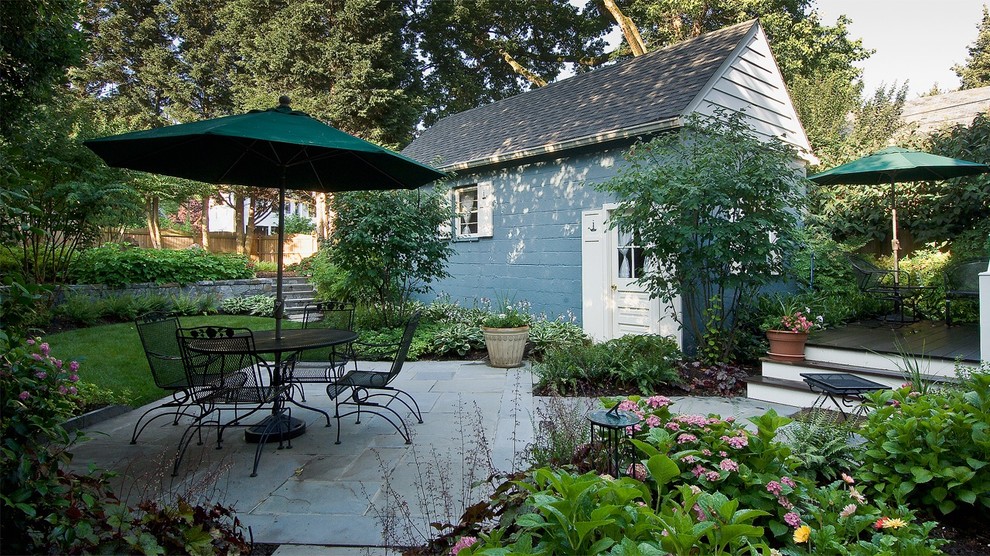This is an example of a small traditional backyard partial sun garden for spring in DC Metro with natural stone pavers.