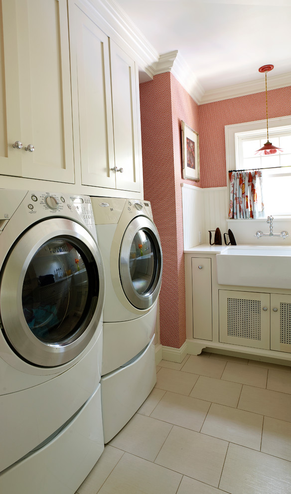 Mid-sized traditional dedicated laundry room in Los Angeles with a farmhouse sink, shaker cabinets, white cabinets, quartz benchtops, red walls, porcelain floors, a side-by-side washer and dryer and beige floor.