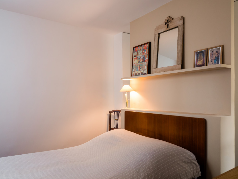 Diseño de dormitorio principal y blanco y madera minimalista grande sin chimenea con paredes beige, suelo de madera en tonos medios y suelo marrón