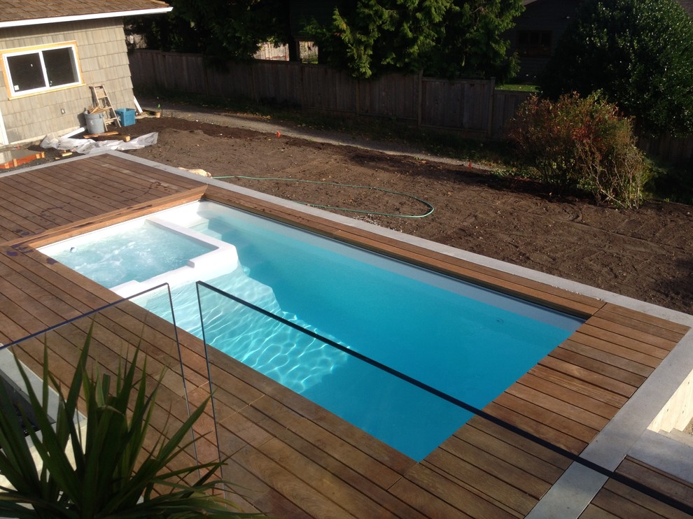 Small contemporary backyard rectangular natural pool in Vancouver with a hot tub and decking.