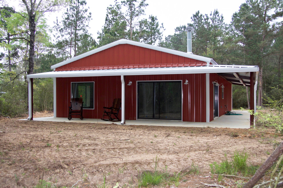 Mid-sized country one-storey red house exterior in Houston with metal siding, a hip roof and a metal roof.