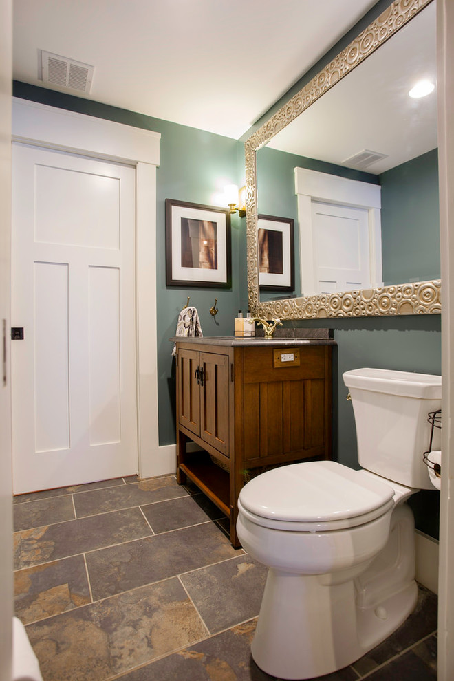 Inspiration for a mid-sized arts and crafts 3/4 bathroom in Boston with recessed-panel cabinets, dark wood cabinets, a two-piece toilet, green walls, slate floors, granite benchtops and an undermount sink.