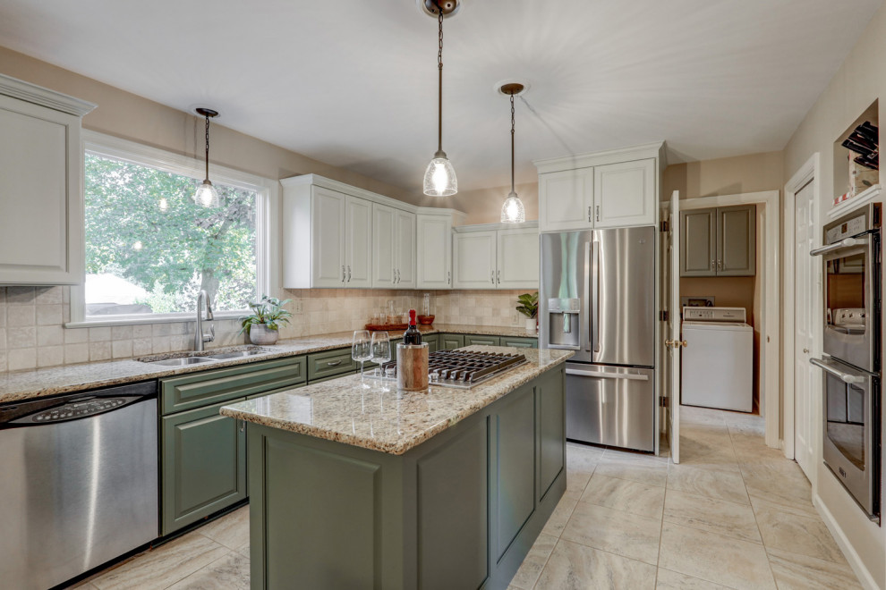 Eat-in kitchen - mid-sized transitional l-shaped ceramic tile and beige floor eat-in kitchen idea with a double-bowl sink, raised-panel cabinets, green cabinets, granite countertops, beige backsplash, ceramic backsplash, stainless steel appliances, an island and beige countertops