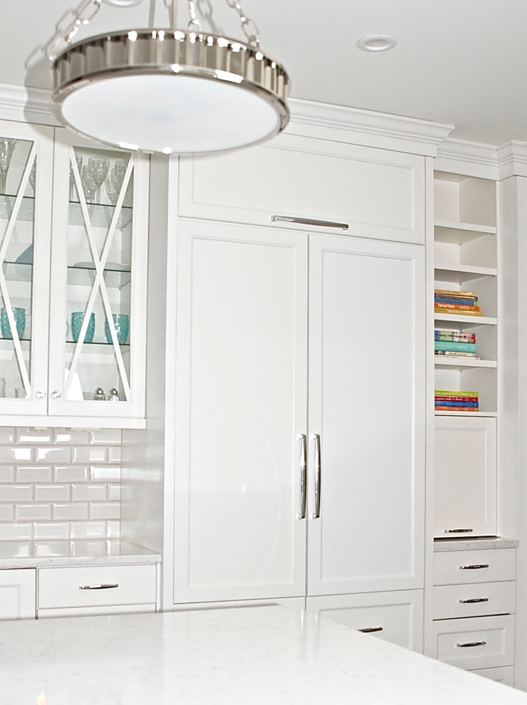 Example of a mid-sized transitional u-shaped dark wood floor eat-in kitchen design in Atlanta with an undermount sink, glass-front cabinets, white cabinets, quartz countertops, white backsplash, subway tile backsplash, paneled appliances and an island