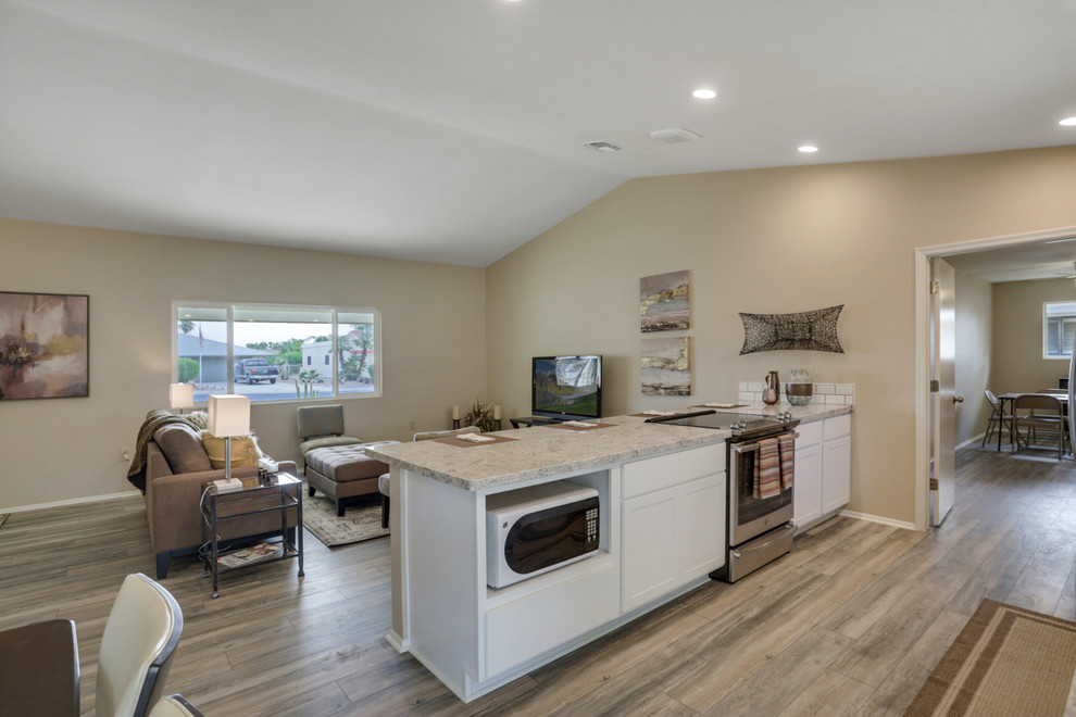 Inspiration for a small transitional single-wall laminate floor and beige floor open concept kitchen remodel in Phoenix with an undermount sink, shaker cabinets, white cabinets, granite countertops, white backsplash, subway tile backsplash, stainless steel appliances, a peninsula and gray countertops