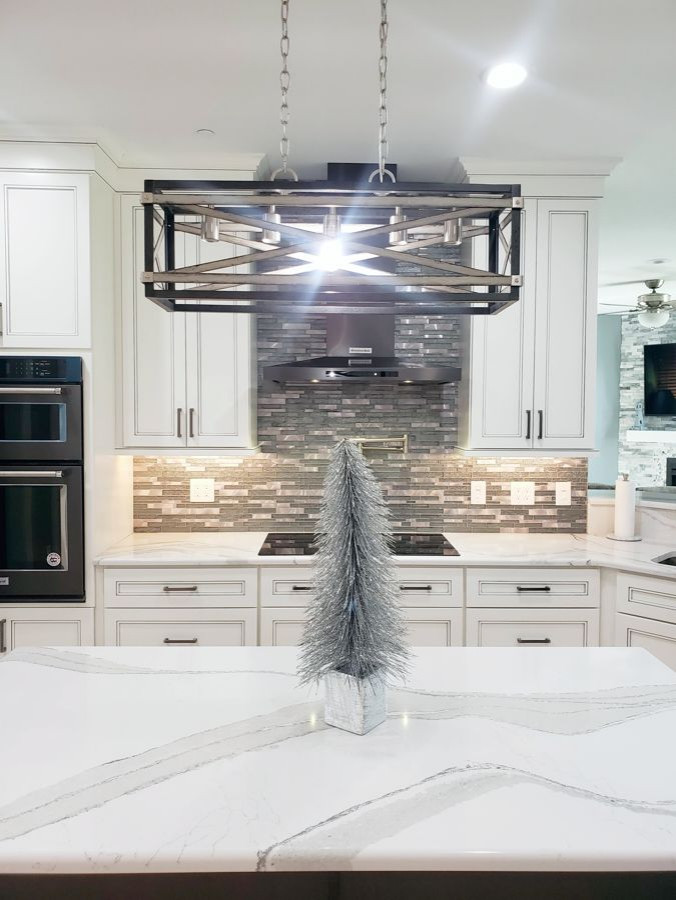 Transitional u-shaped eat-in kitchen photo with recessed-panel cabinets, white cabinets, quartz countertops, multicolored backsplash, mosaic tile backsplash, two islands and white countertops