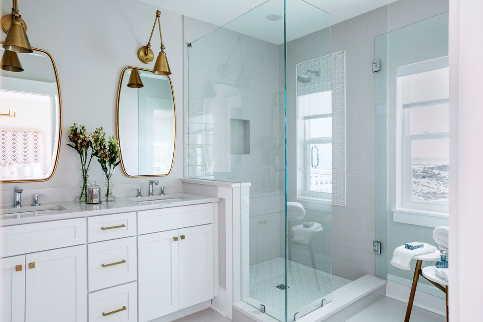 This is an example of a mid-sized transitional 3/4 bathroom in Miami with shaker cabinets, white cabinets, a corner shower, gray tile, subway tile, grey walls, porcelain floors, an undermount sink, quartzite benchtops, beige floor and a hinged shower door.