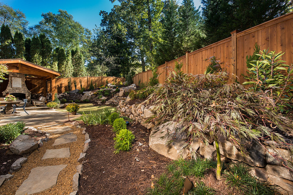 Photo of a large tropical backyard partial sun garden in Atlanta with a fire feature and natural stone pavers.