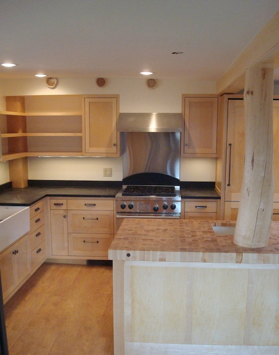 Eat-in kitchen - mid-sized l-shaped medium tone wood floor eat-in kitchen idea with medium tone wood cabinets, solid surface countertops, stainless steel appliances and an island