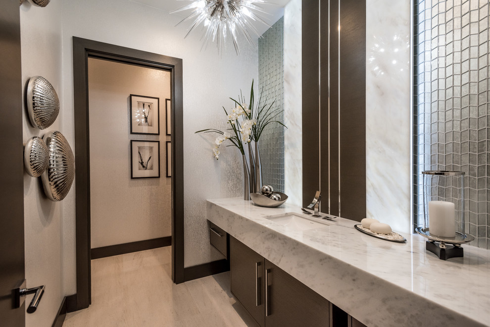 Design ideas for a large contemporary powder room in Las Vegas with flat-panel cabinets, brown cabinets, grey walls, light hardwood floors, an undermount sink, marble benchtops, beige floor and grey benchtops.