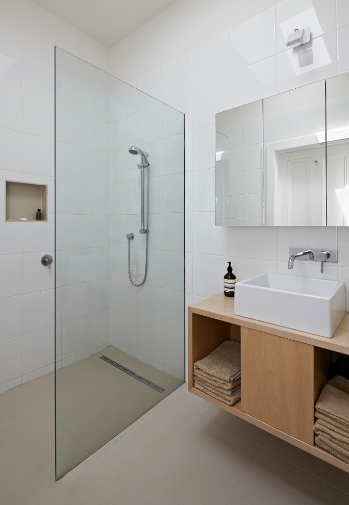 Inspiration for a contemporary bathroom in Melbourne with a vessel sink, open cabinets, light wood cabinets, wood benchtops, a curbless shower, white tile and brown benchtops.