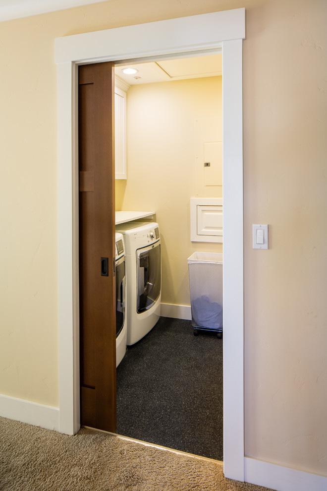 This is an example of a mid-sized transitional galley dedicated laundry room in San Francisco with shaker cabinets, white cabinets, beige walls and a side-by-side washer and dryer.
