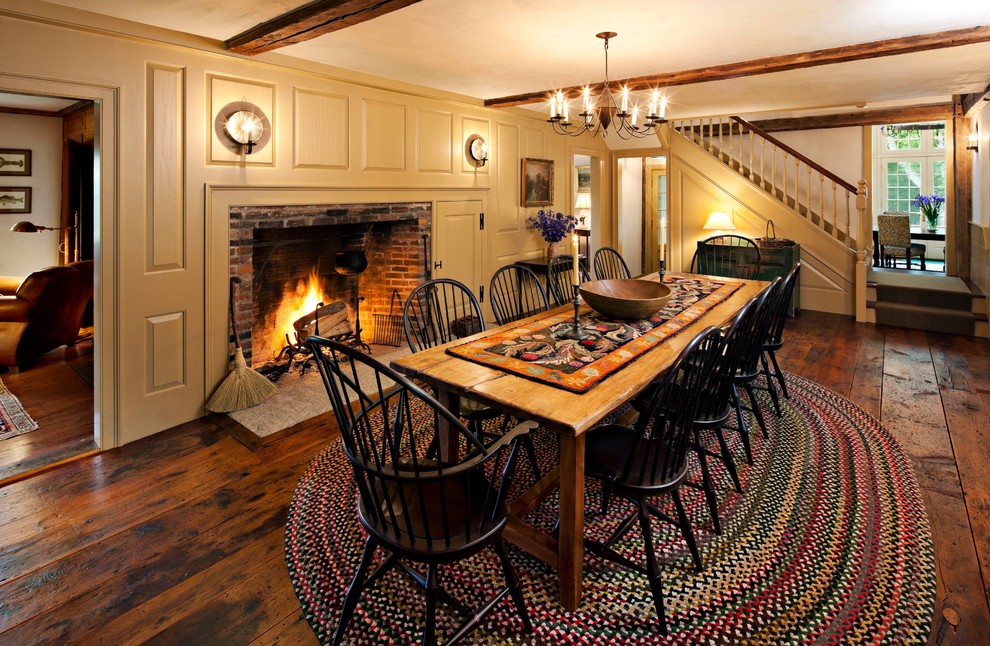 Design ideas for an expansive country separate dining room in New York with medium hardwood floors, a standard fireplace and a brick fireplace surround.