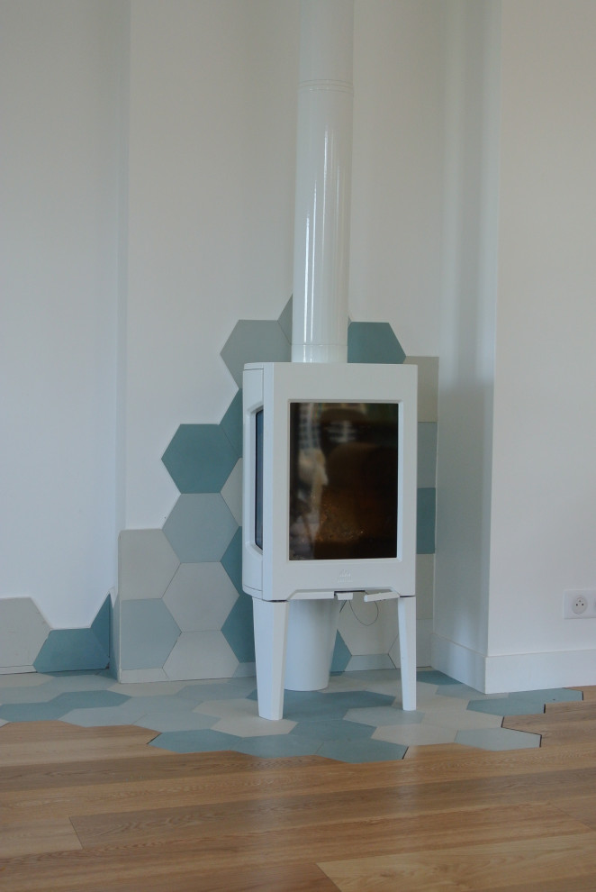 Immagine di un soggiorno minimalista di medie dimensioni e aperto con pareti bianche, parquet chiaro, stufa a legna, nessuna TV e pavimento marrone
