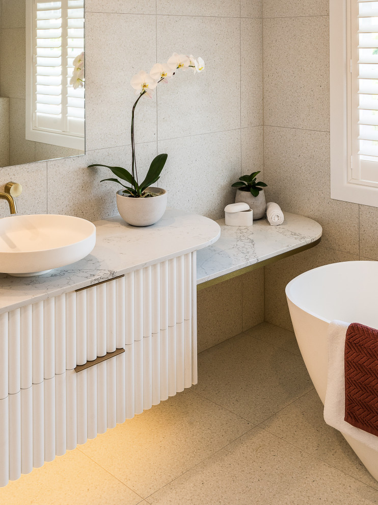 Réalisation d'une grande salle de bain principale design avec une baignoire indépendante, un carrelage beige, un sol en carrelage de céramique, aucune cabine, meuble double vasque et meuble-lavabo suspendu.