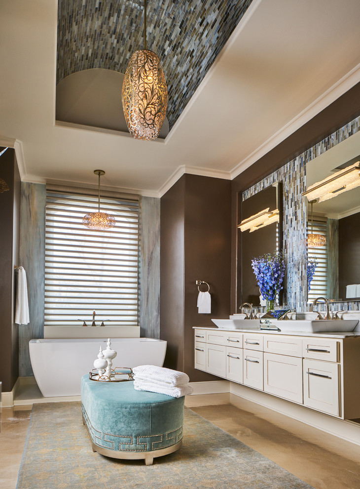Large transitional master bathroom in Other with shaker cabinets, a freestanding tub, multi-coloured tile, glass tile, brown walls, concrete floors, a vessel sink, marble benchtops, grey floor, beige cabinets and white benchtops.