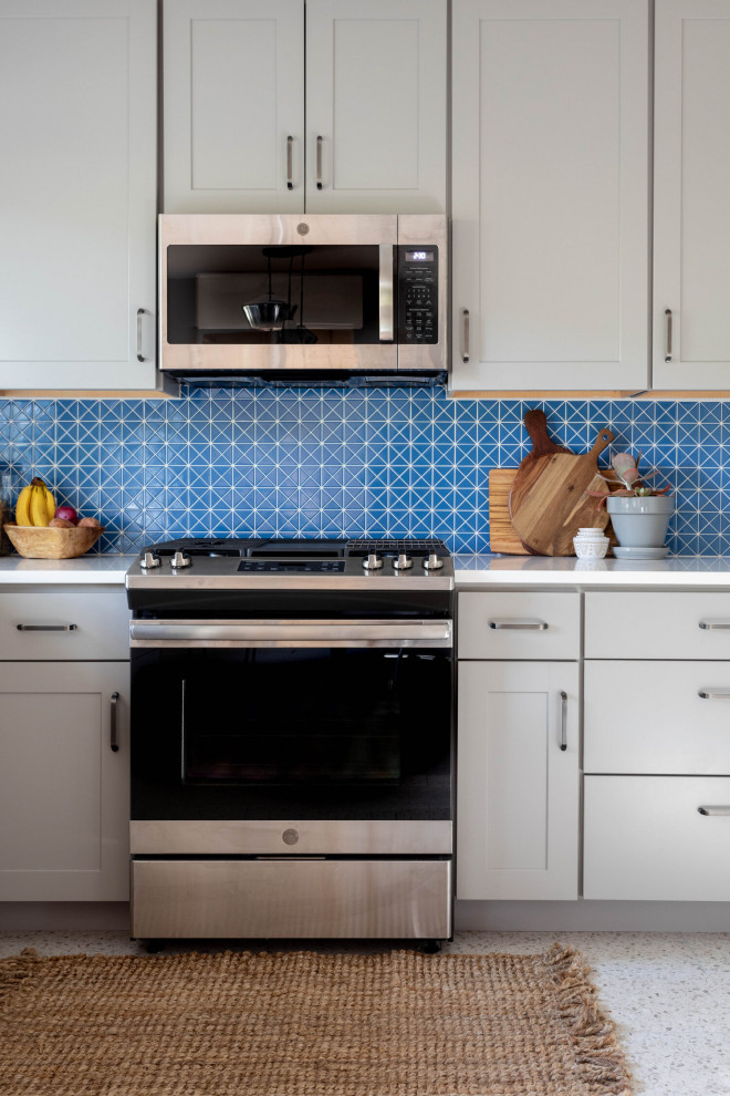 Inspiration for a mid-sized transitional l-shaped multicolored floor enclosed kitchen remodel in Austin with an undermount sink, shaker cabinets, gray cabinets, quartz countertops, blue backsplash, ceramic backsplash, stainless steel appliances, no island and white countertops