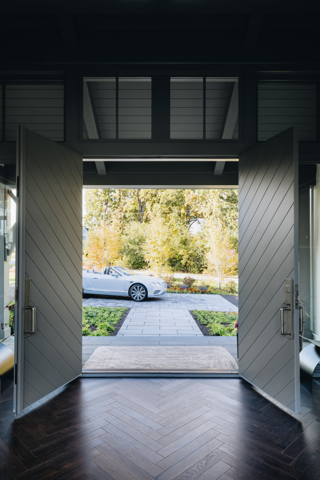 Example of a large transitional dark wood floor, brown floor and vaulted ceiling front door design in Chicago with a gray front door and gray walls