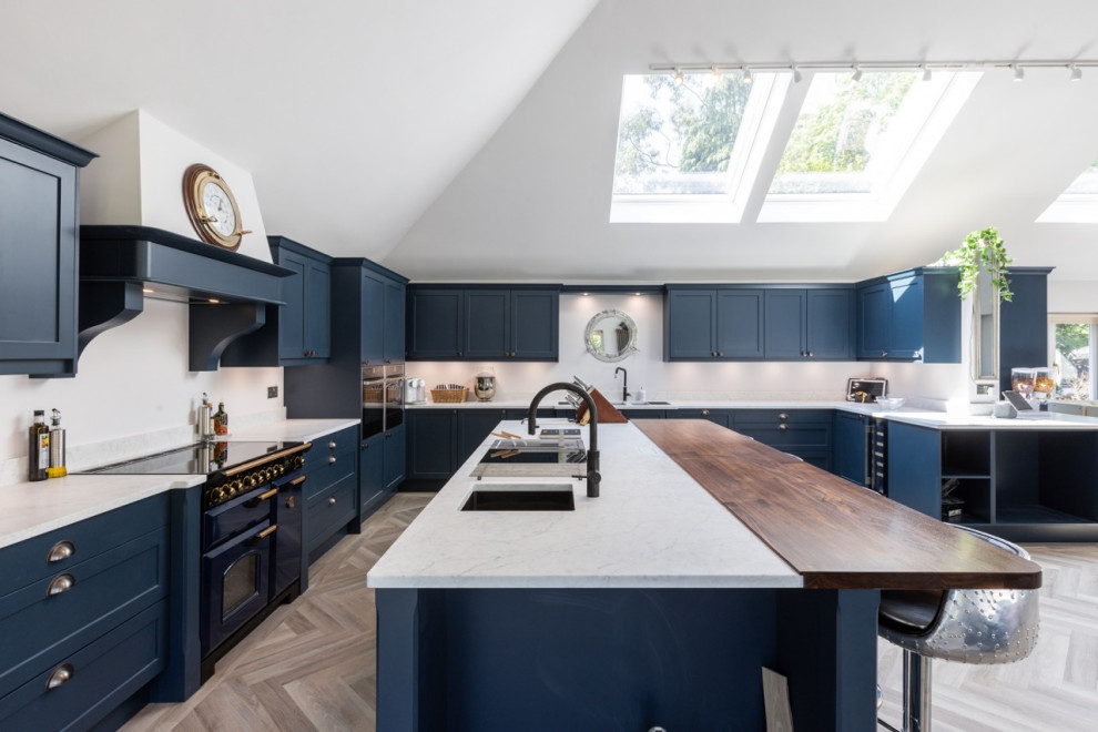 Diseño de cocina contemporánea grande abierta con armarios estilo shaker, puertas de armario azules, encimera de cuarcita, una isla y encimeras blancas